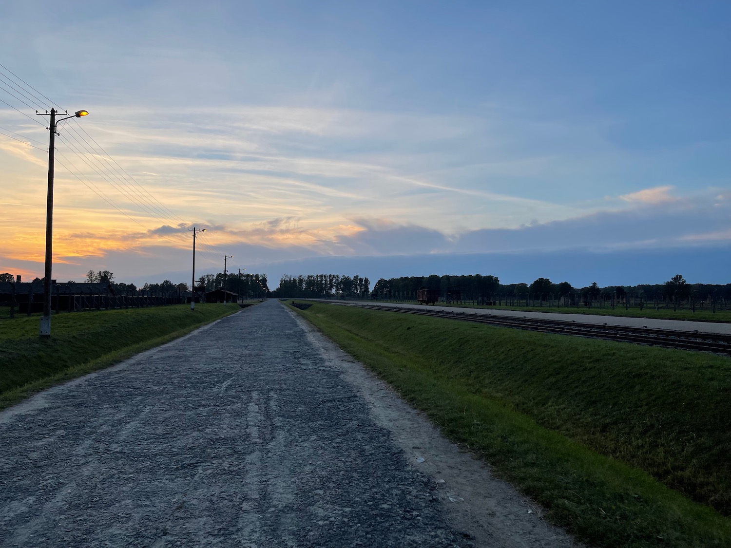 a road with grass and train tracks