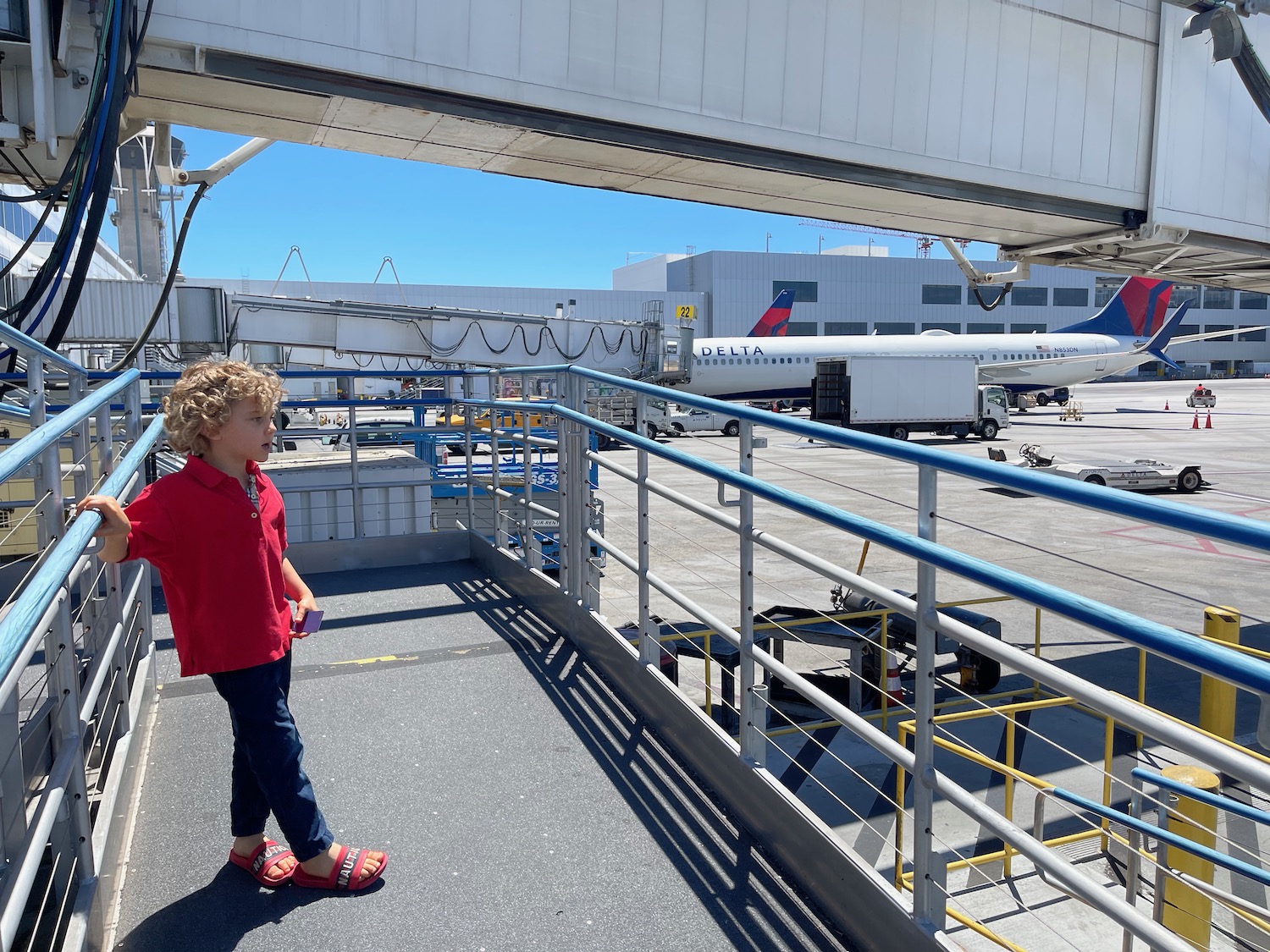 a child standing on a deck near an airplane