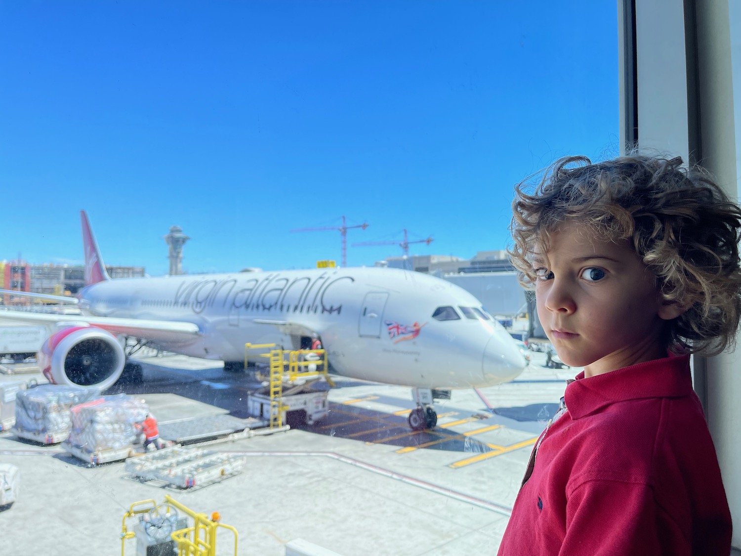 a boy looking out a window at an airplane