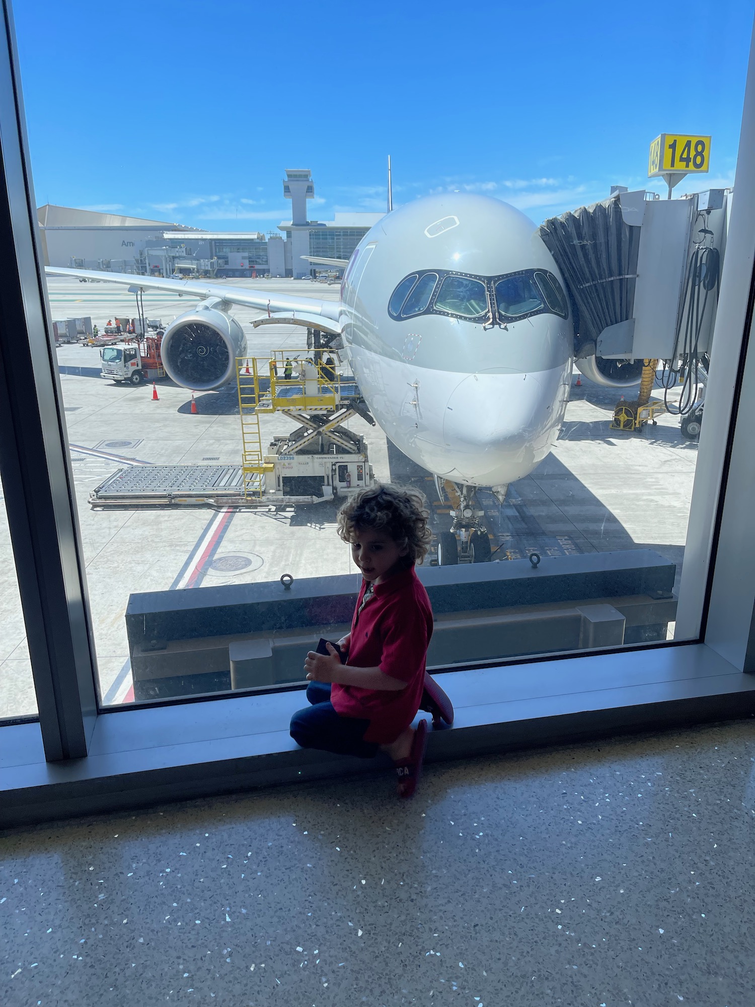 a child sitting on a window sill in an airport