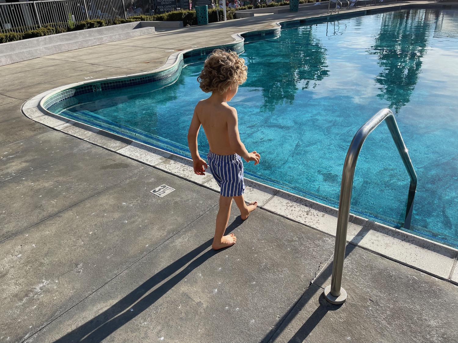 a child standing by a pool