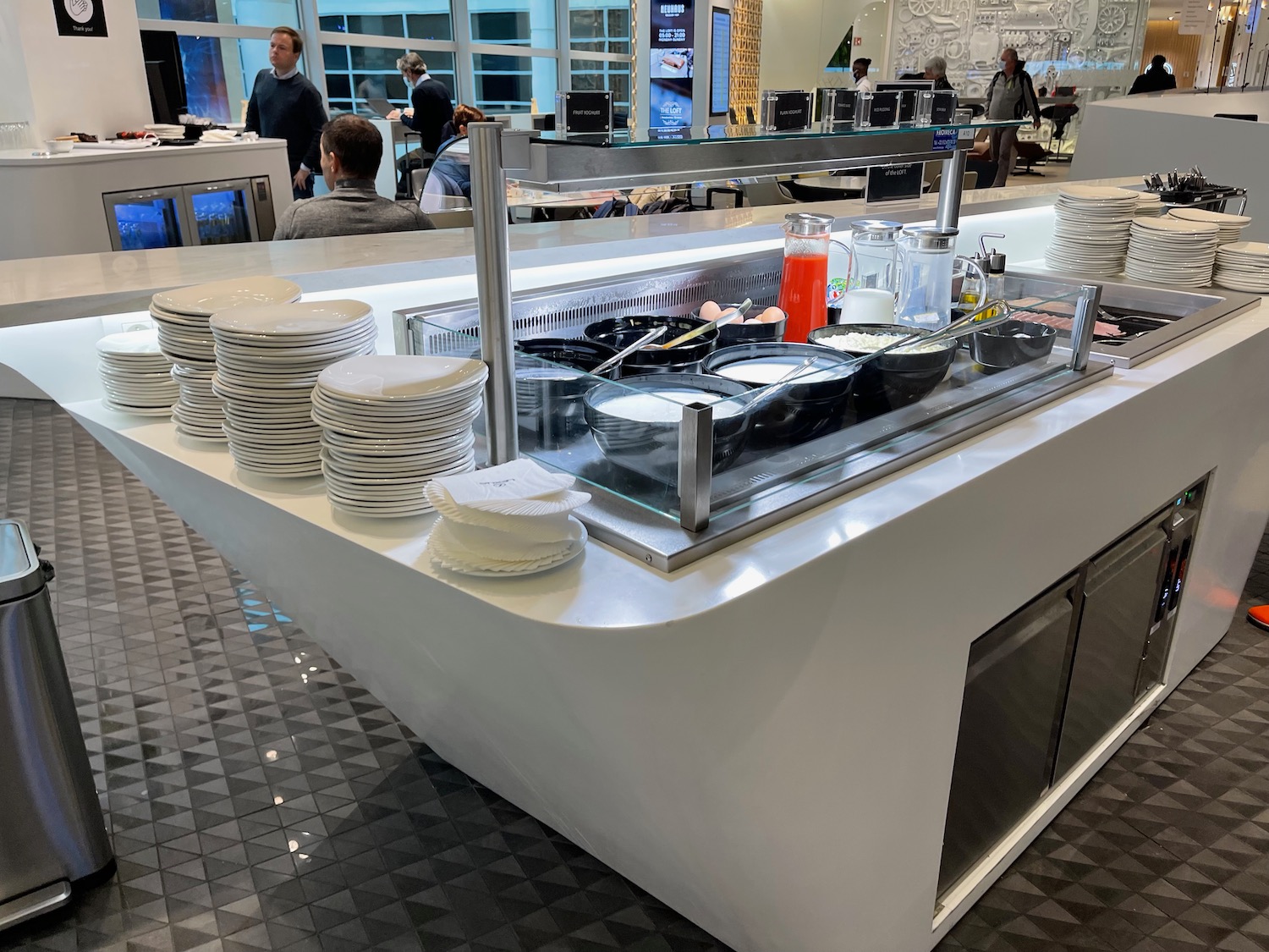 a buffet with plates and bowls on the counter