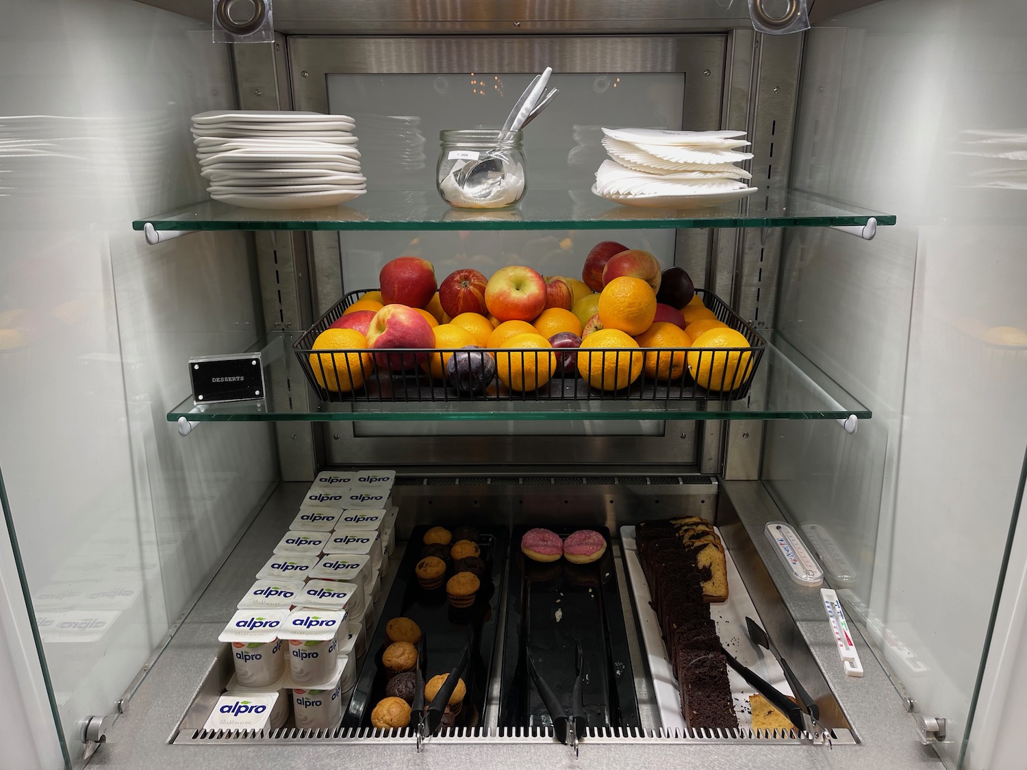 a shelf of fruit and desserts