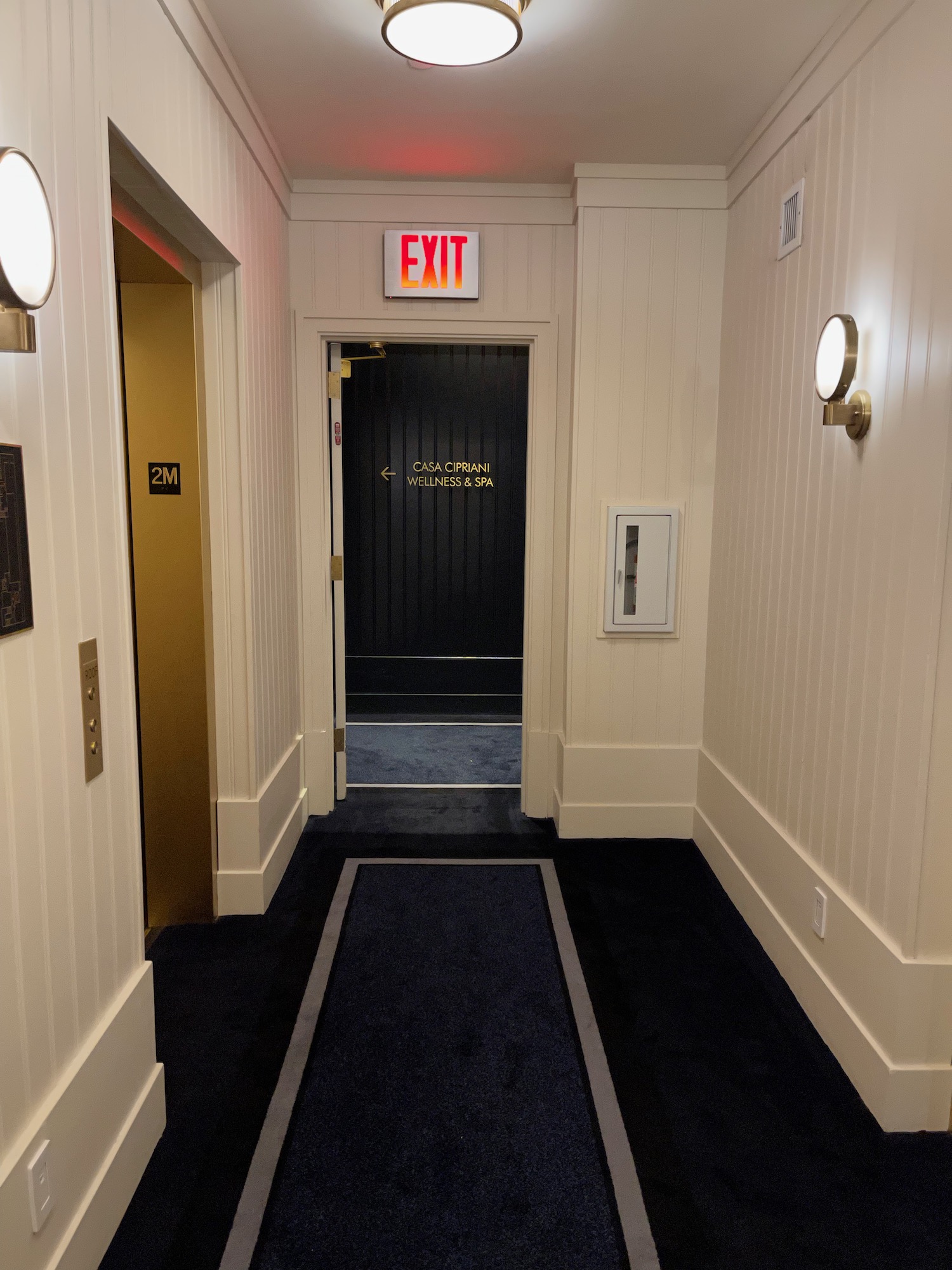 a hallway with a black door and a black carpet