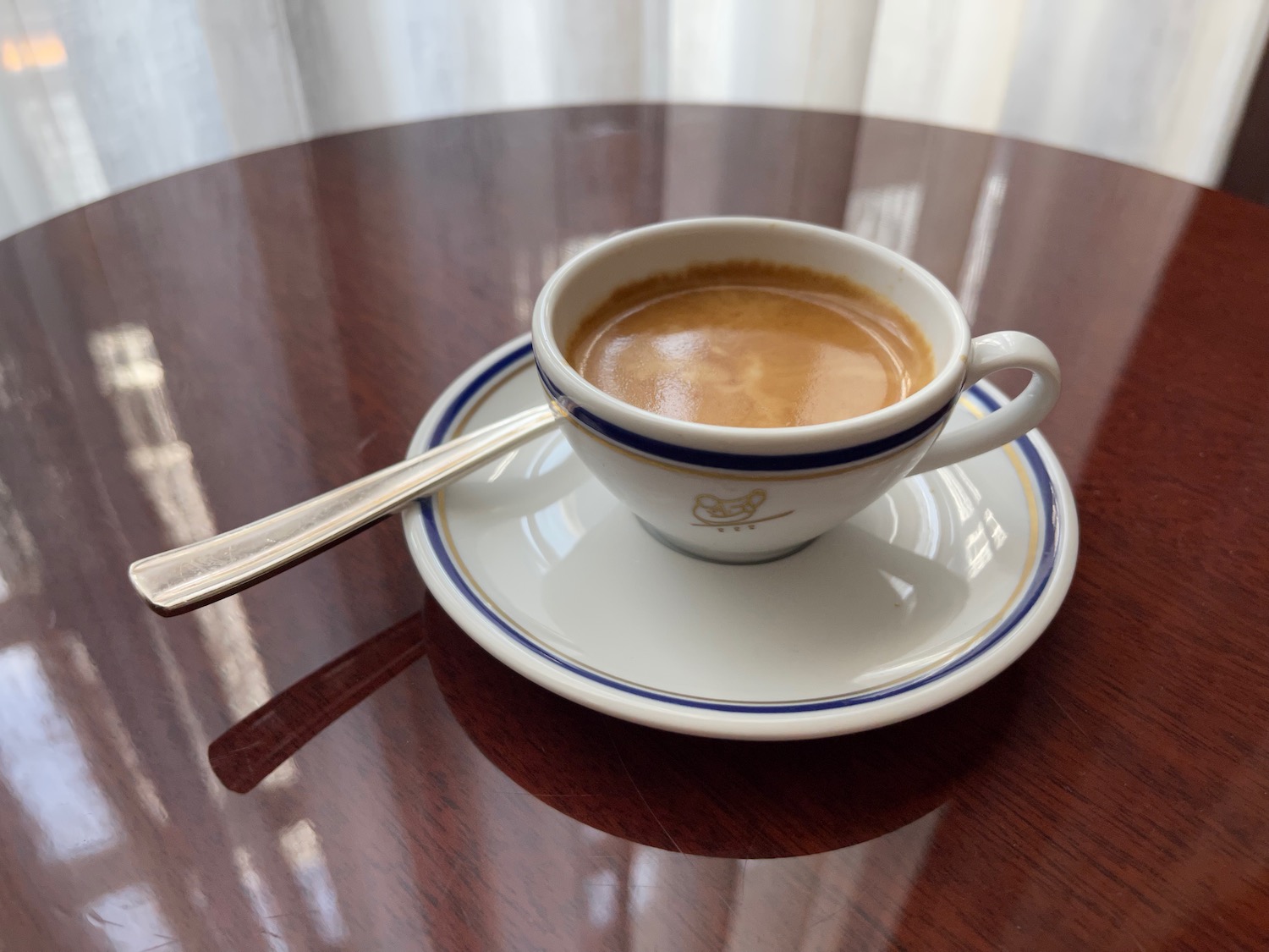 a cup of coffee on a saucer with a spoon