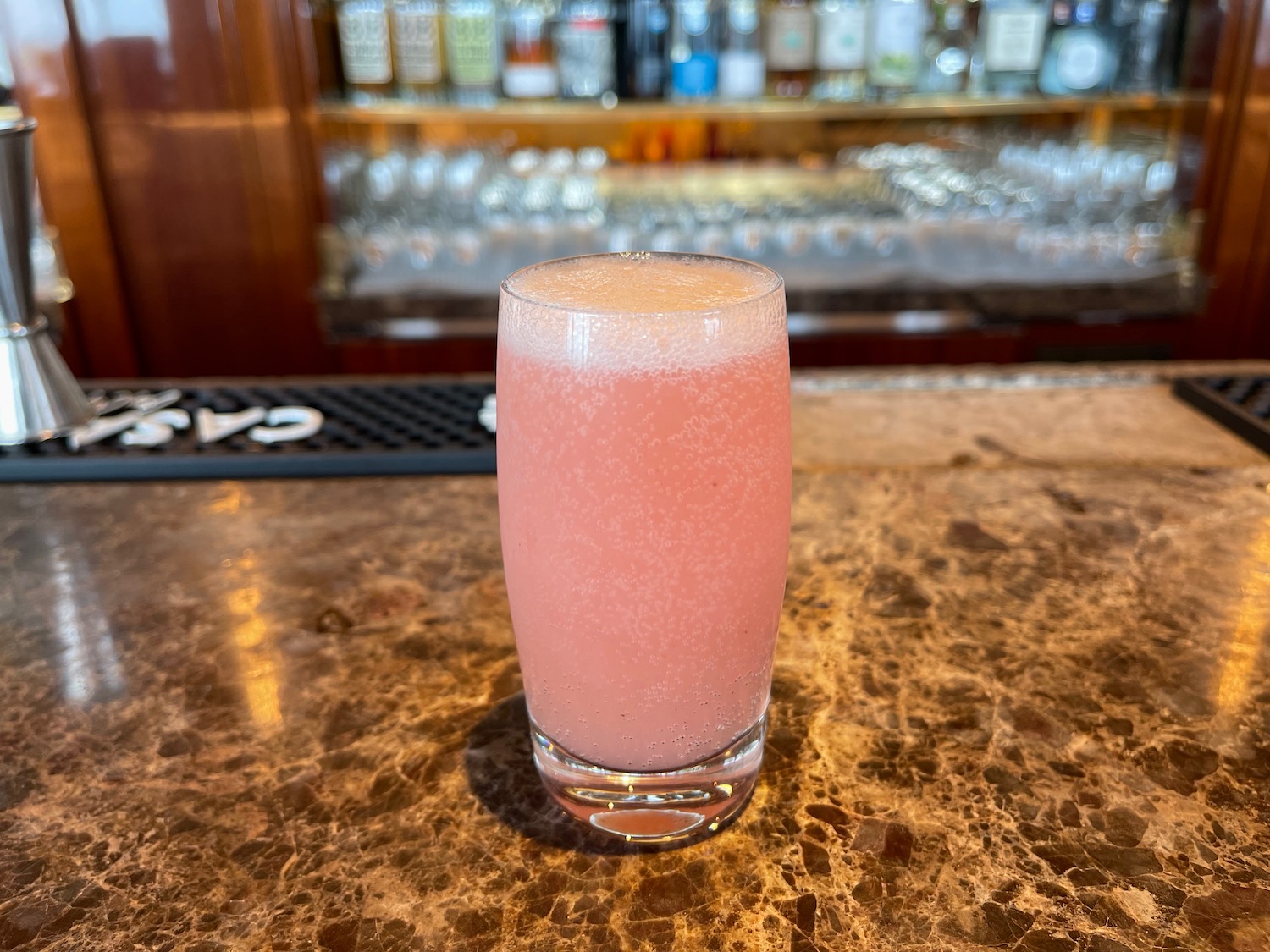 a glass of pink liquid on a counter