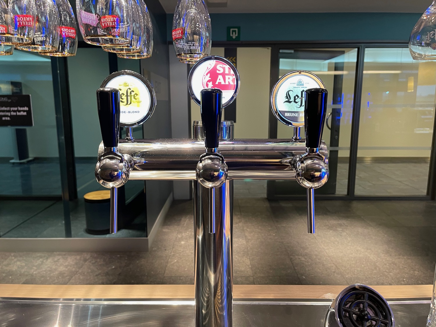 a beer tap with many glasses from it