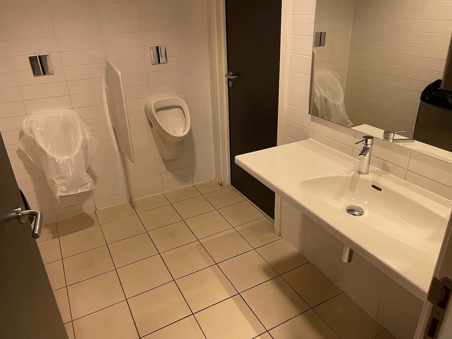 a bathroom with a urinal and a mirror