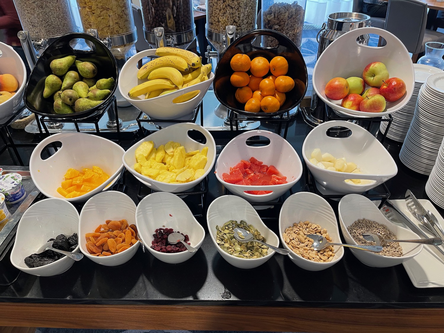 a group of bowls of fruit and cereals