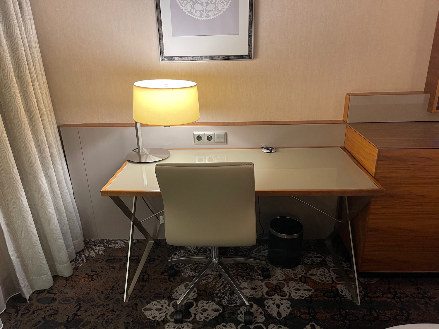 a desk with a lamp and chair in a room