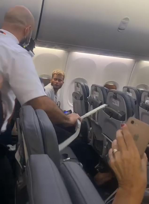 a man in a white shirt and glasses on a plane