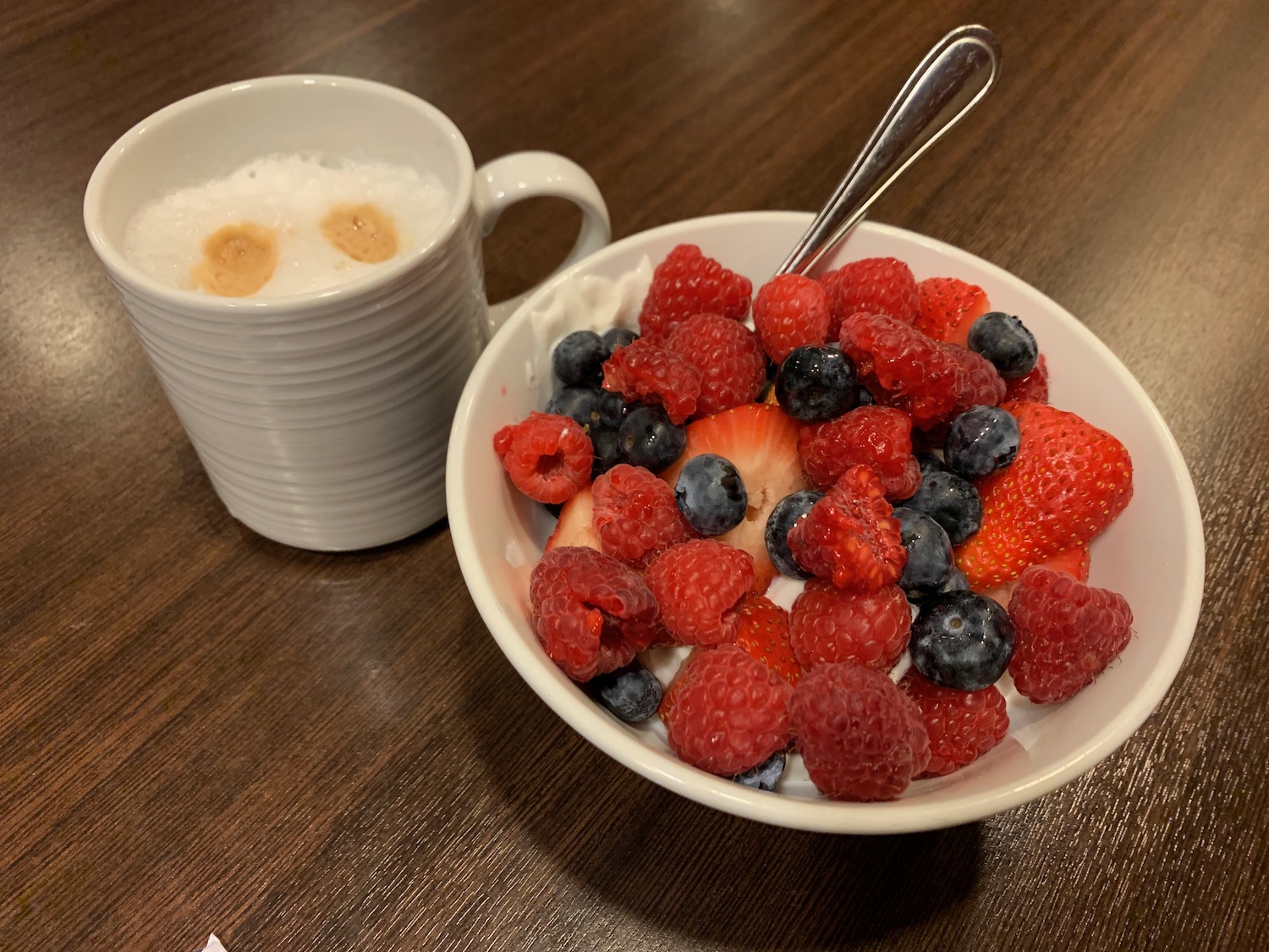 a bowl of fruit and a cup of coffee