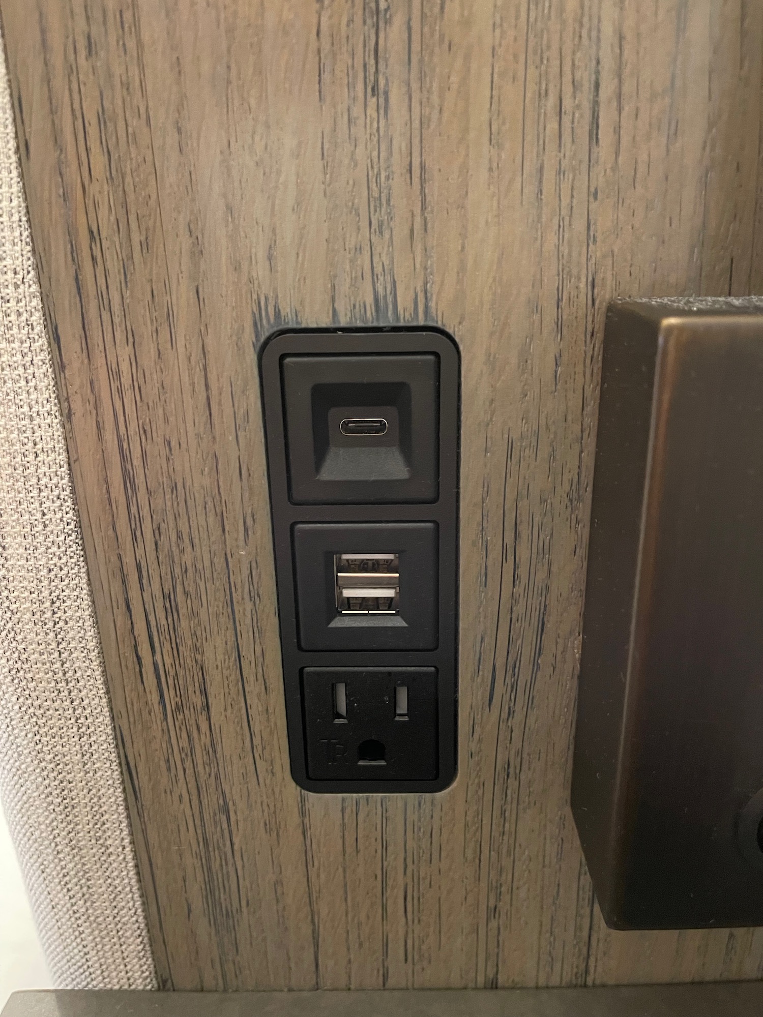 a black outlet with usb ports on a wood wall