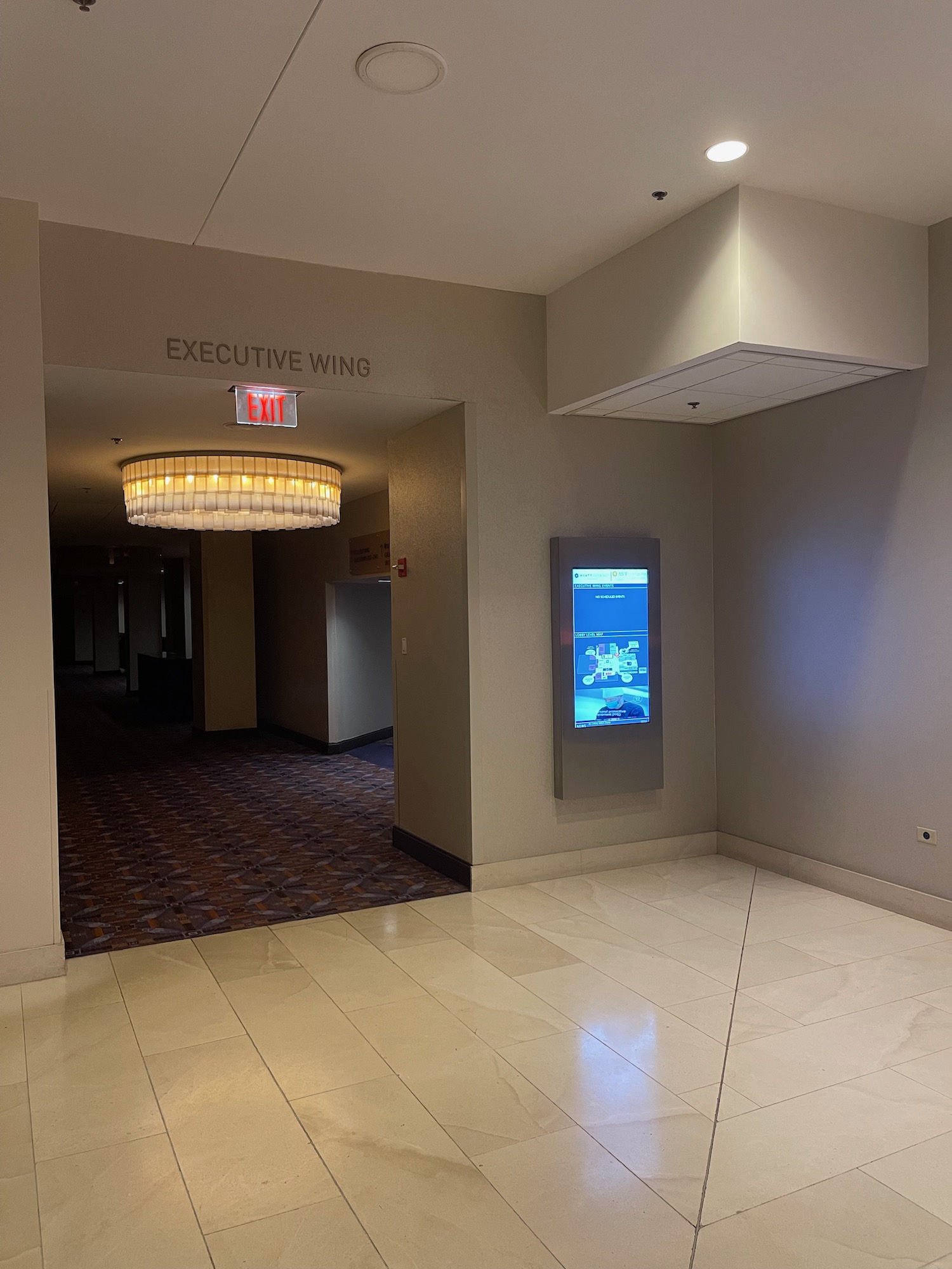 an empty hallway with an electronic screen