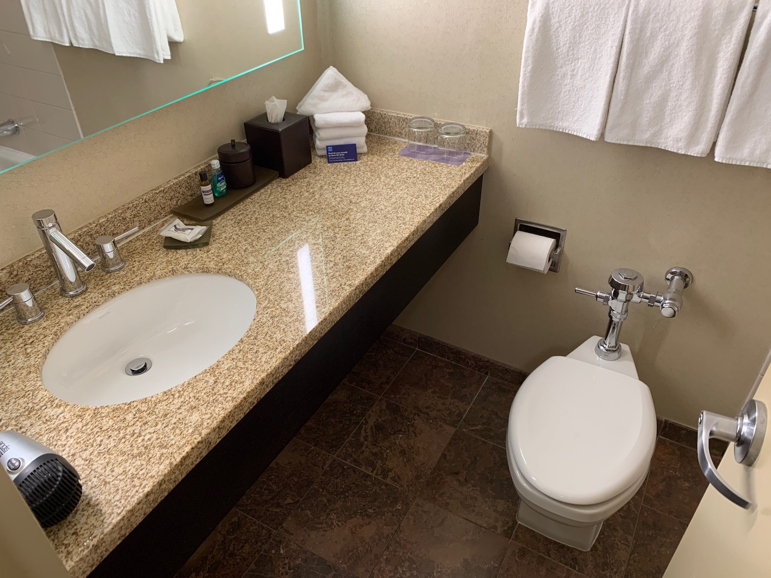 a bathroom with a marble countertop and a toilet