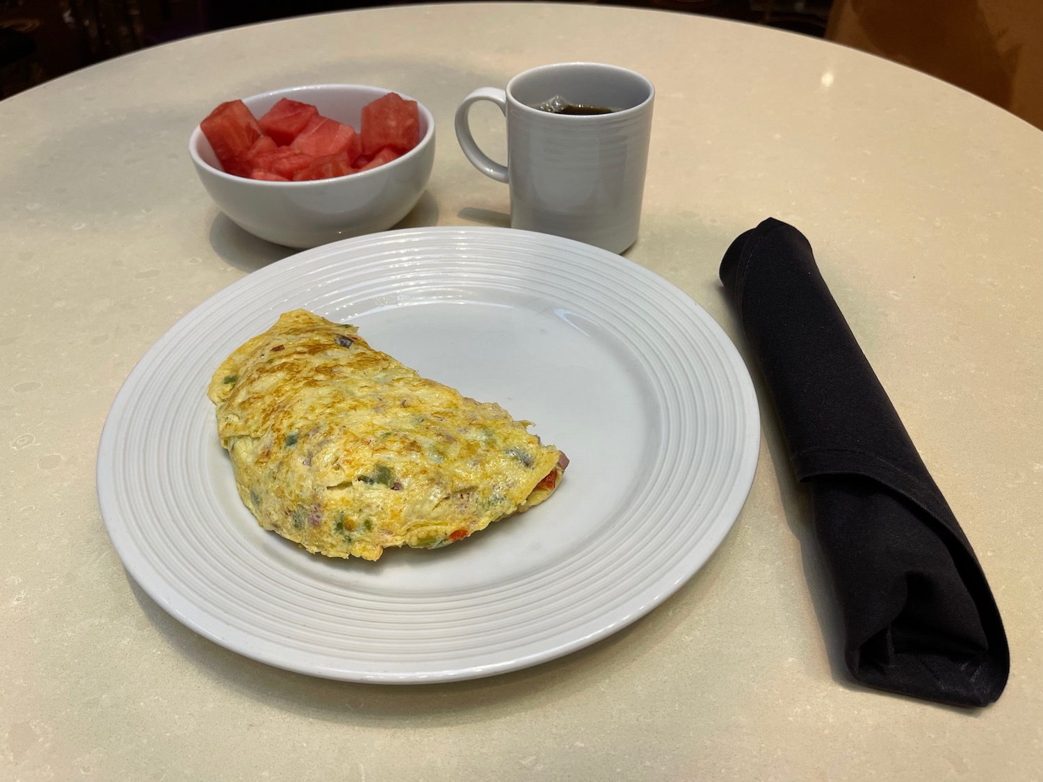 a plate of omelette and a bowl of watermelon