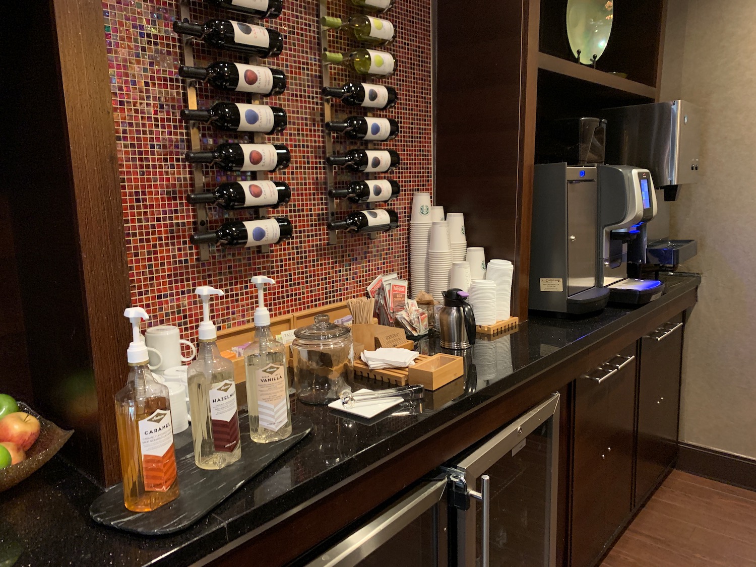 a counter with bottles of wine and cups on it