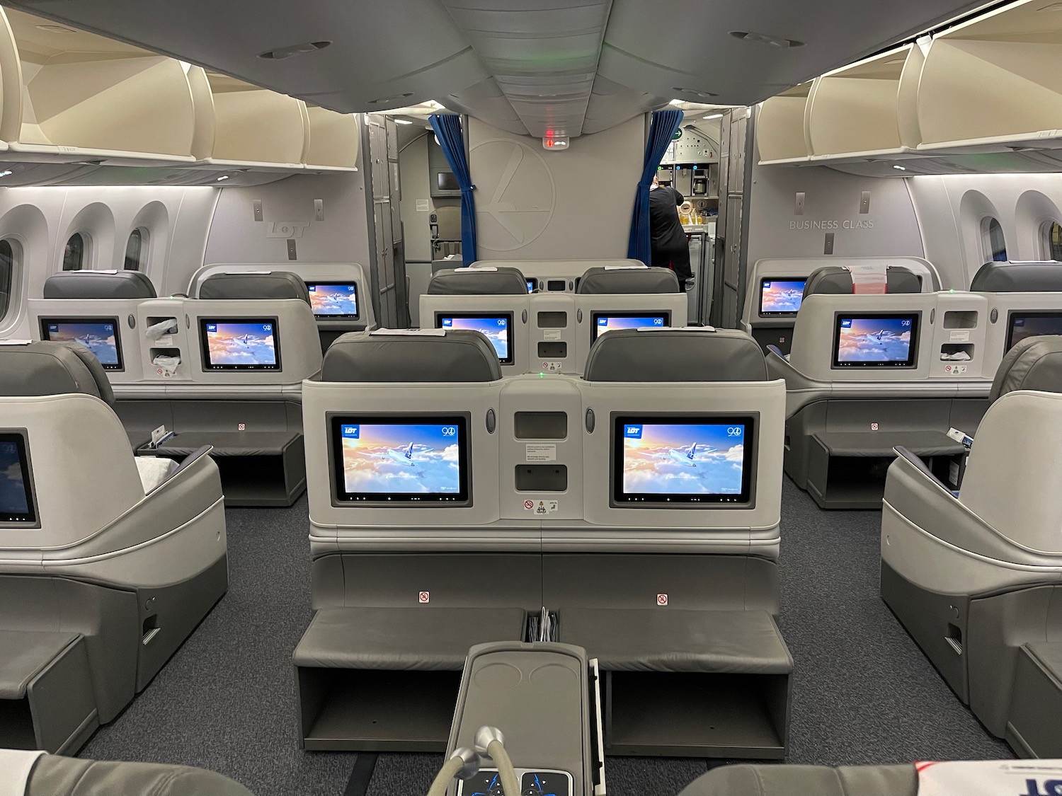 a row of seats with monitors in the middle of an airplane