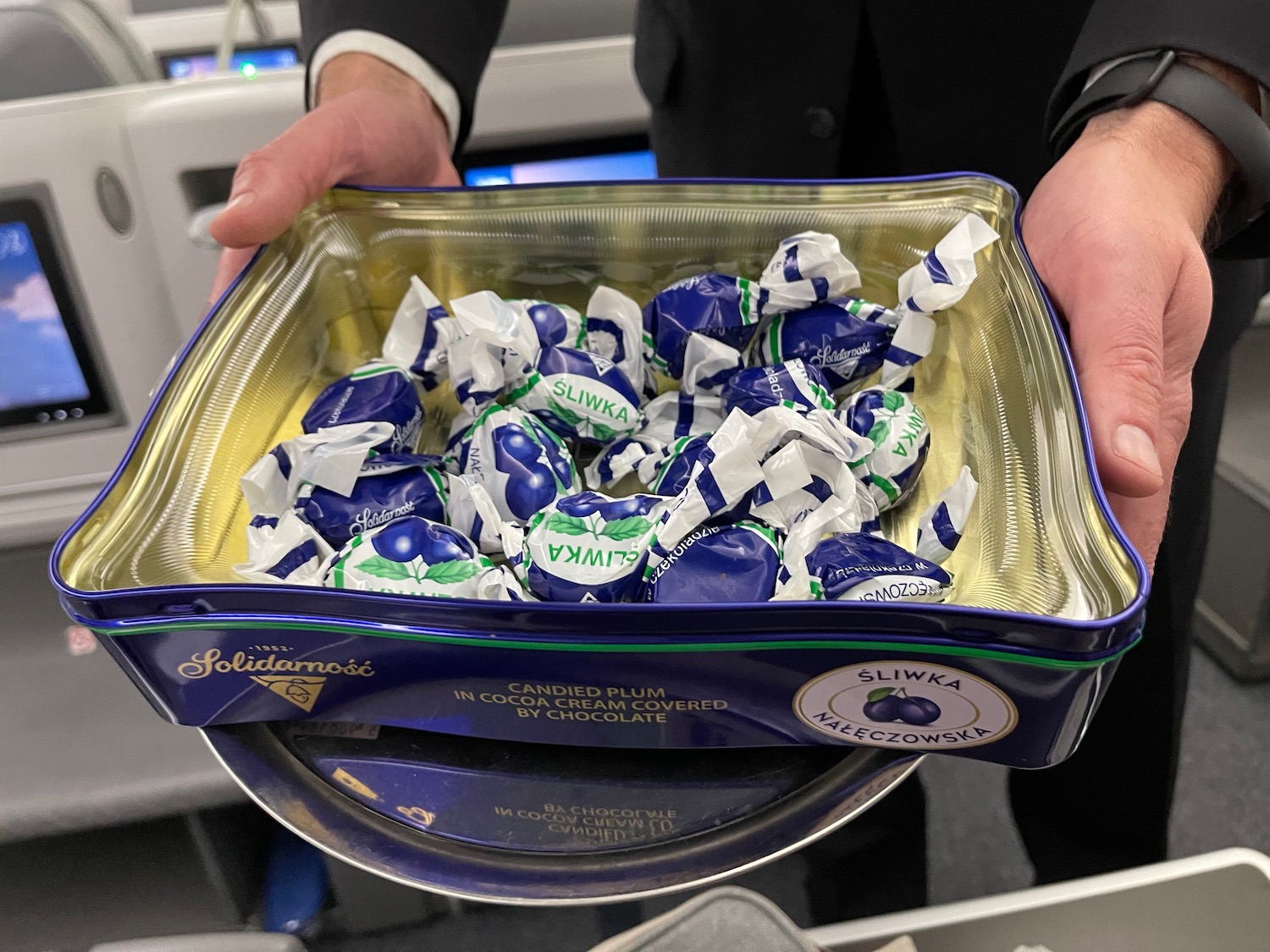 a person holding a tray of candy