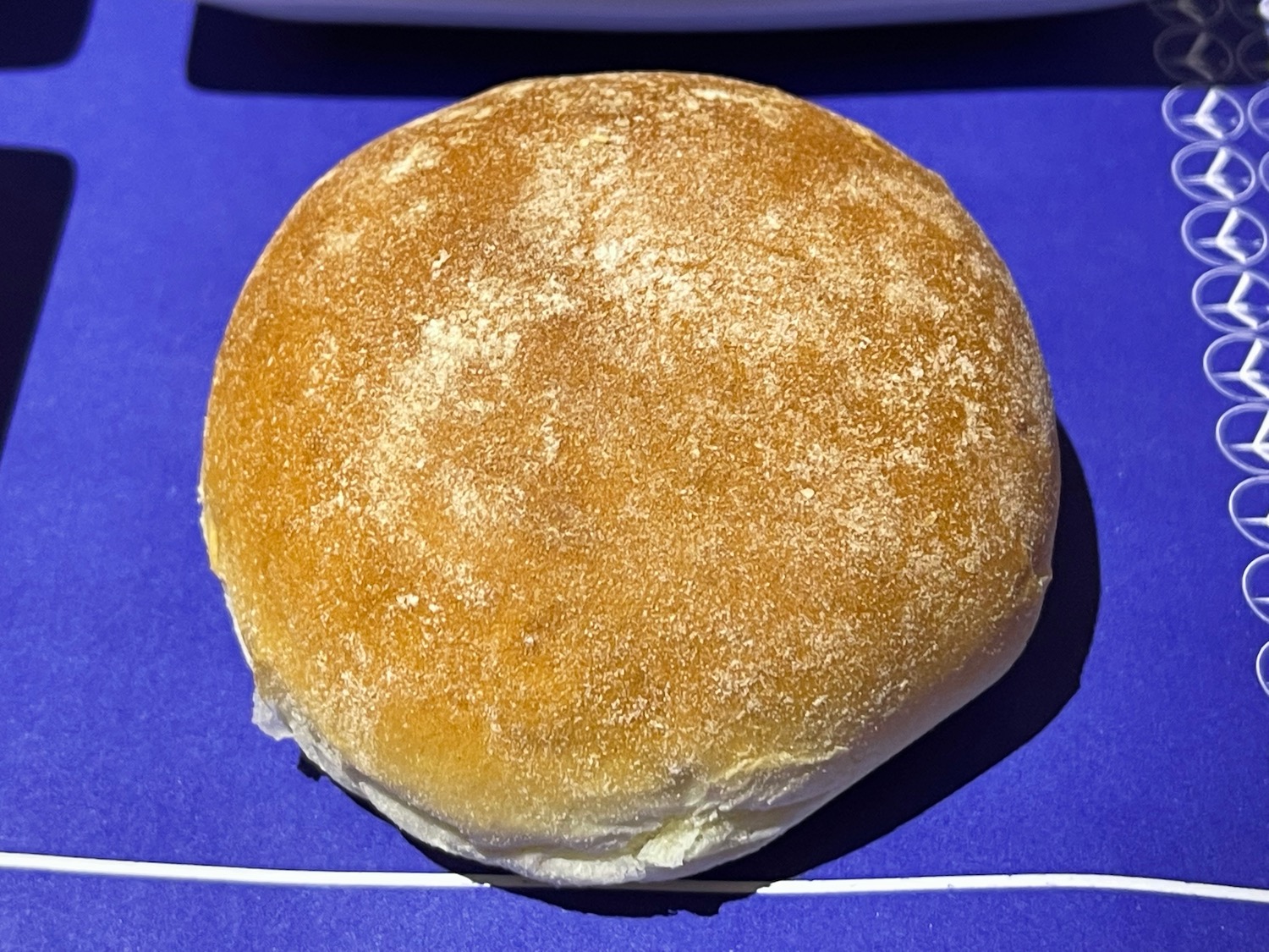 a round brown bread roll on a blue surface