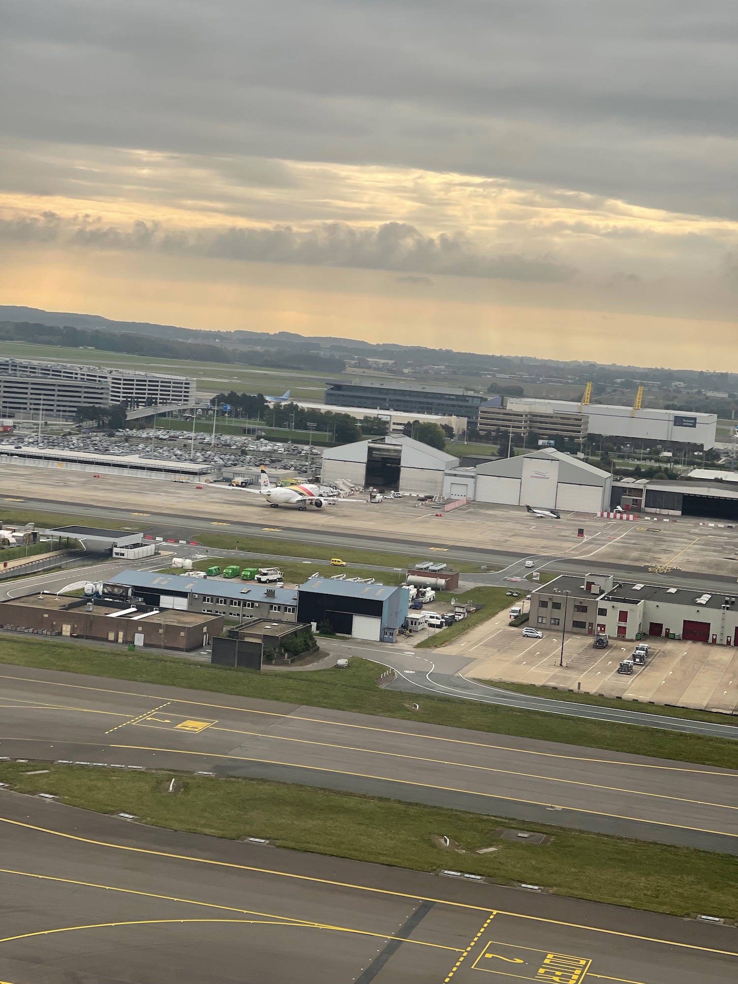 an airport runway with buildings and a parking lot