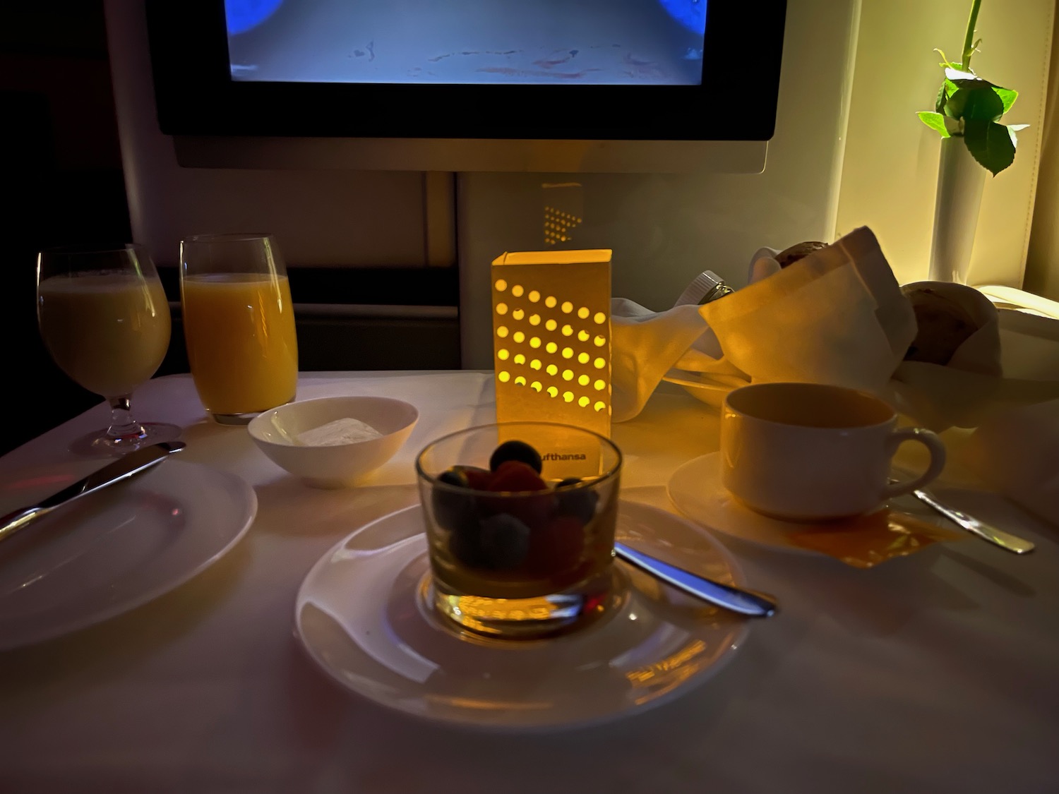 a table with plates and glasses of juice and a bowl of fruit