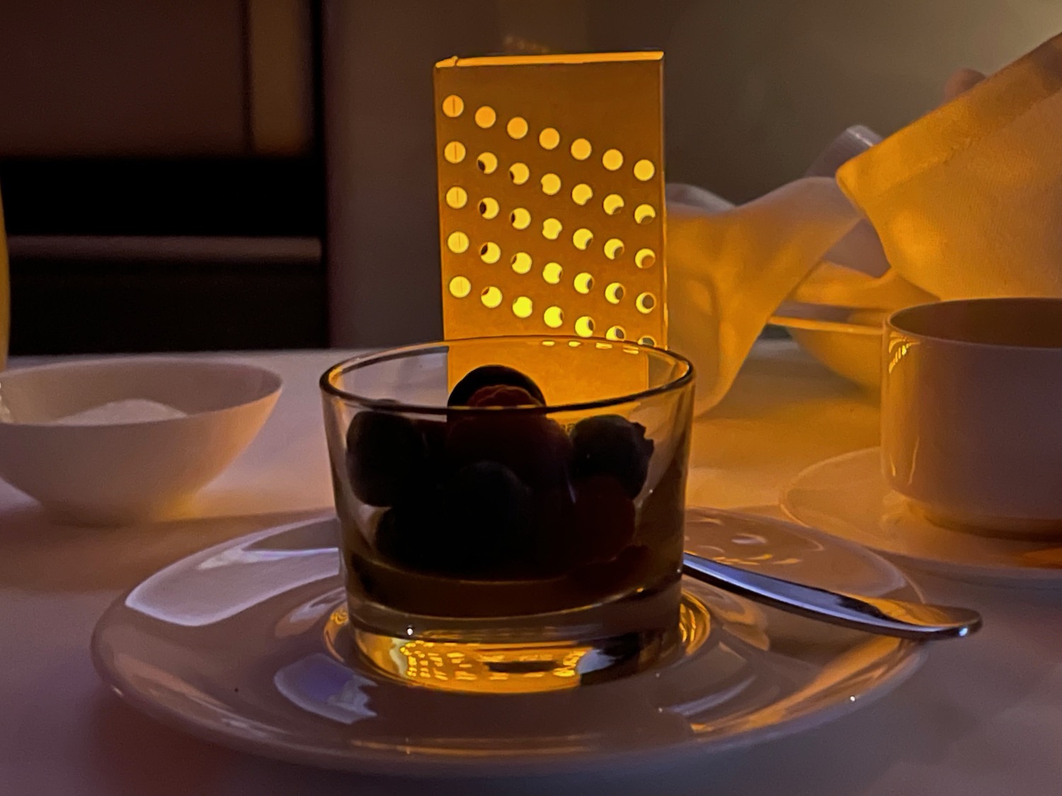 a glass cup with berries on a plate