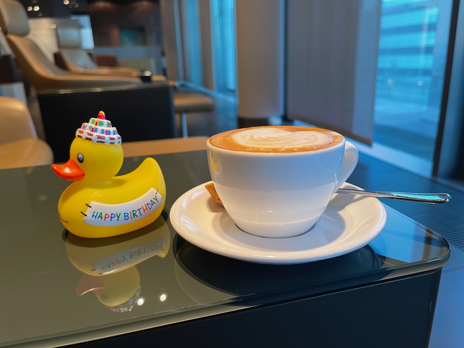 a cup of coffee and a rubber duck on a table