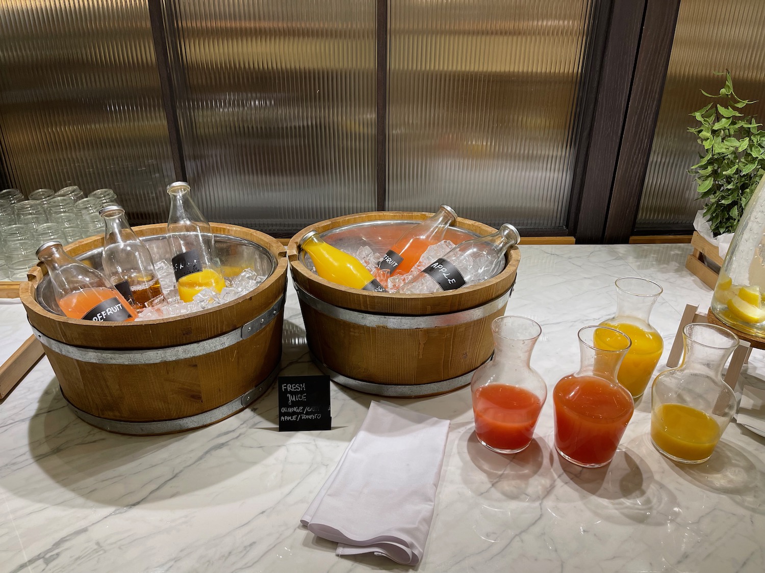 a group of wooden buckets with ice and bottles of juice on a table