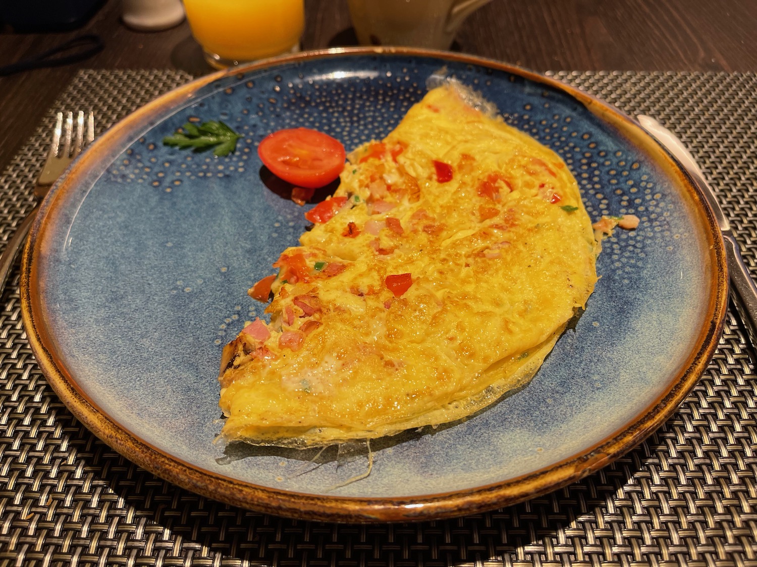 a plate of omelette with tomato and parsley