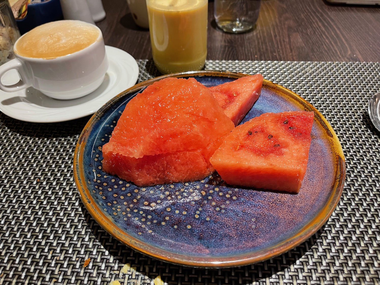 a plate of watermelon and a cup of coffee