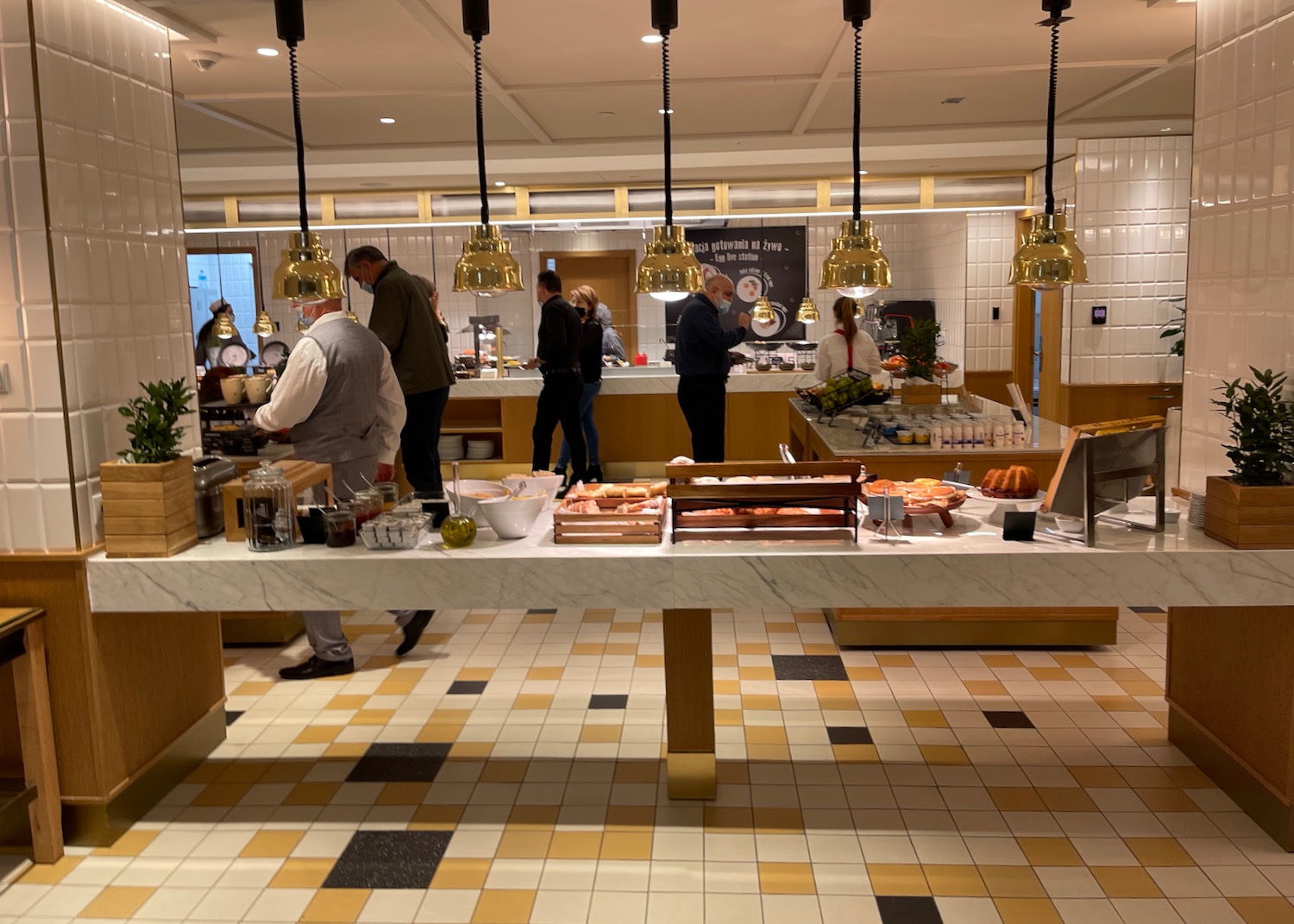 people in a restaurant with people standing around a counter