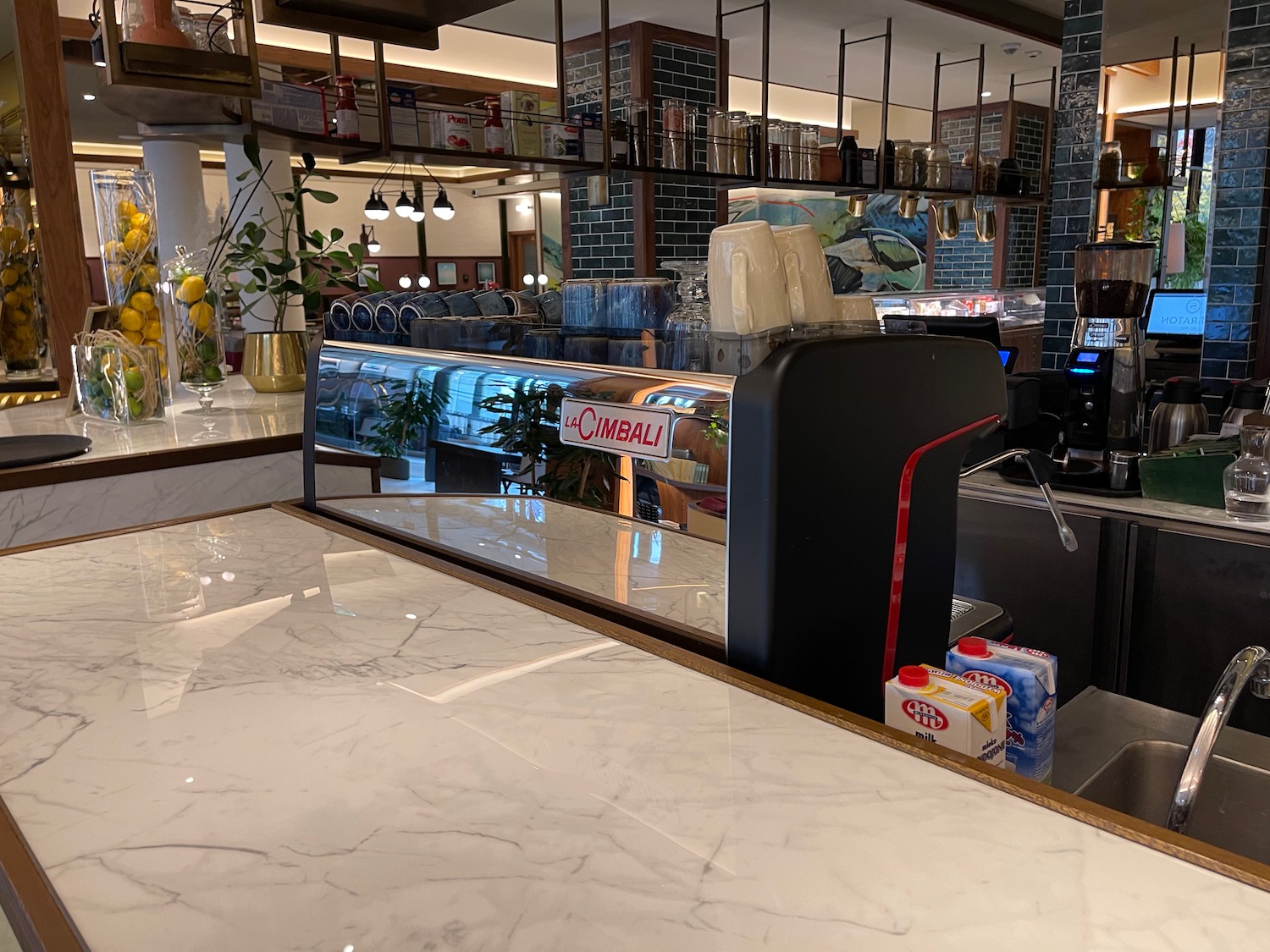 a counter with a coffee machine and a glass shelf