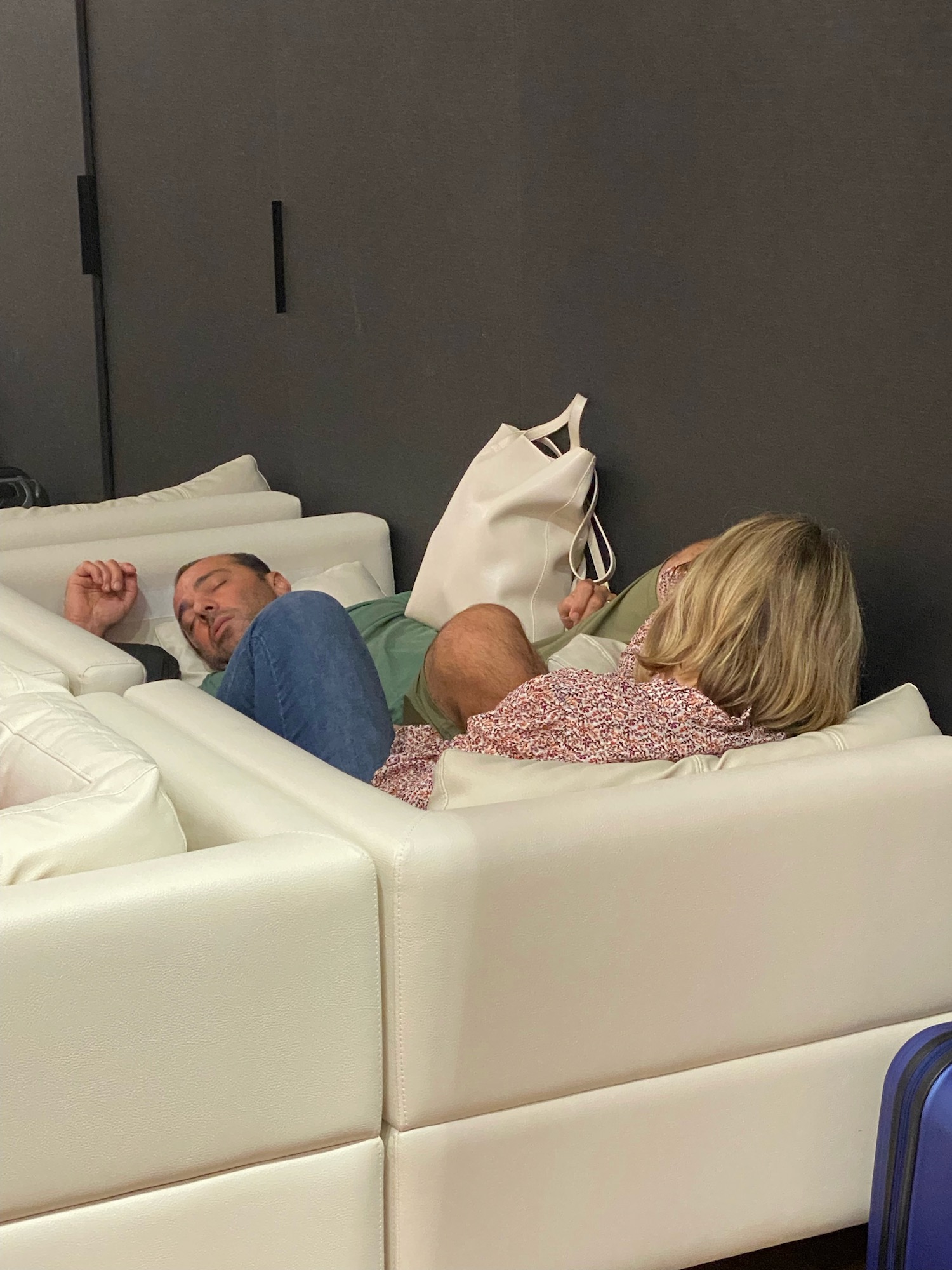 a man and woman sleeping on white couches