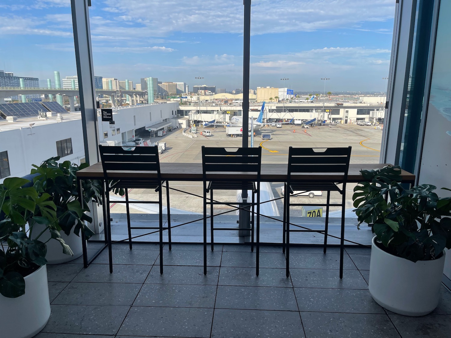 a table and chairs in a room with a view of an airport