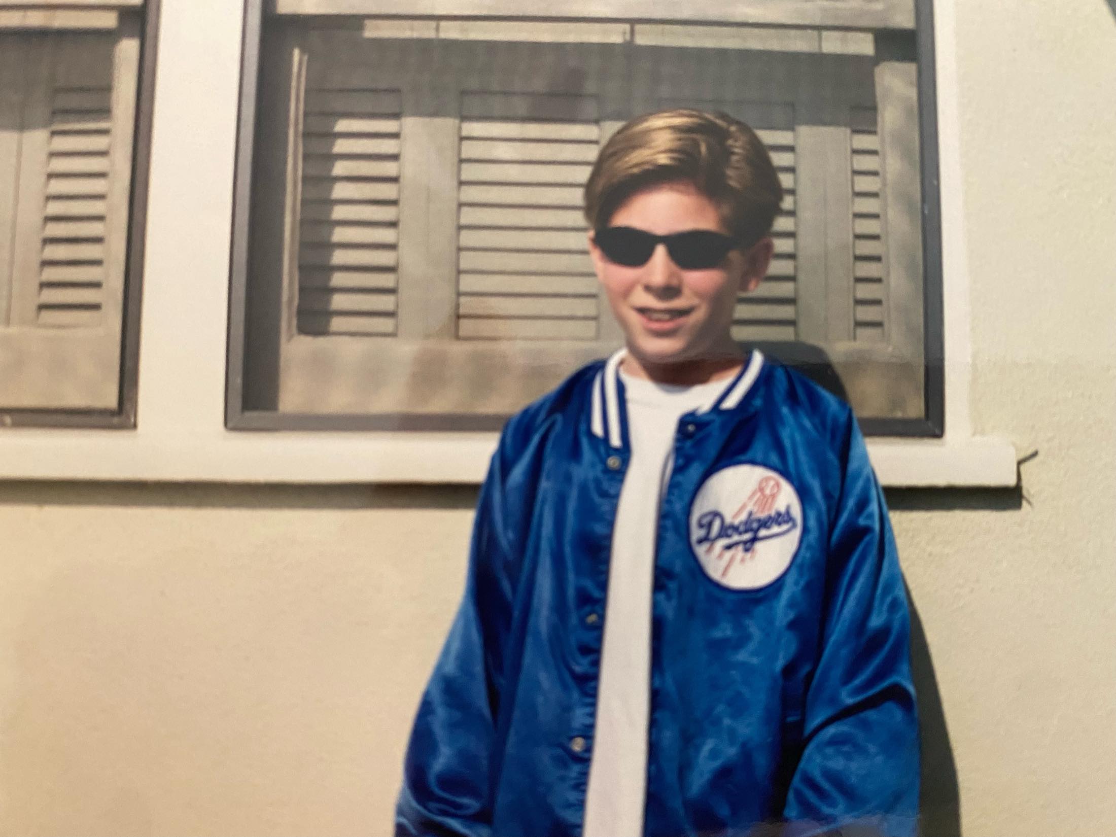 a boy wearing sunglasses and a blue jacket