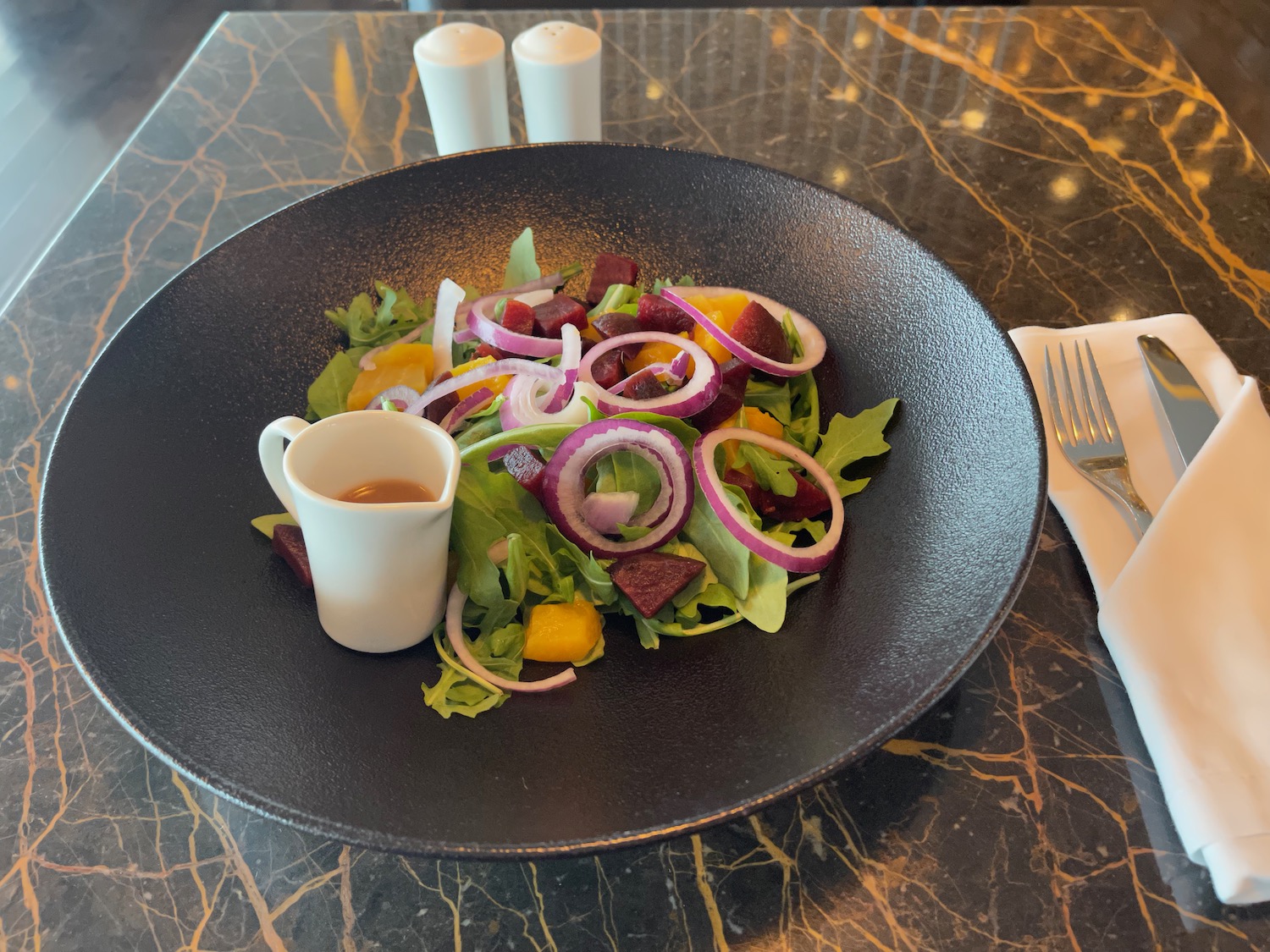 a plate of salad with a fork and knife