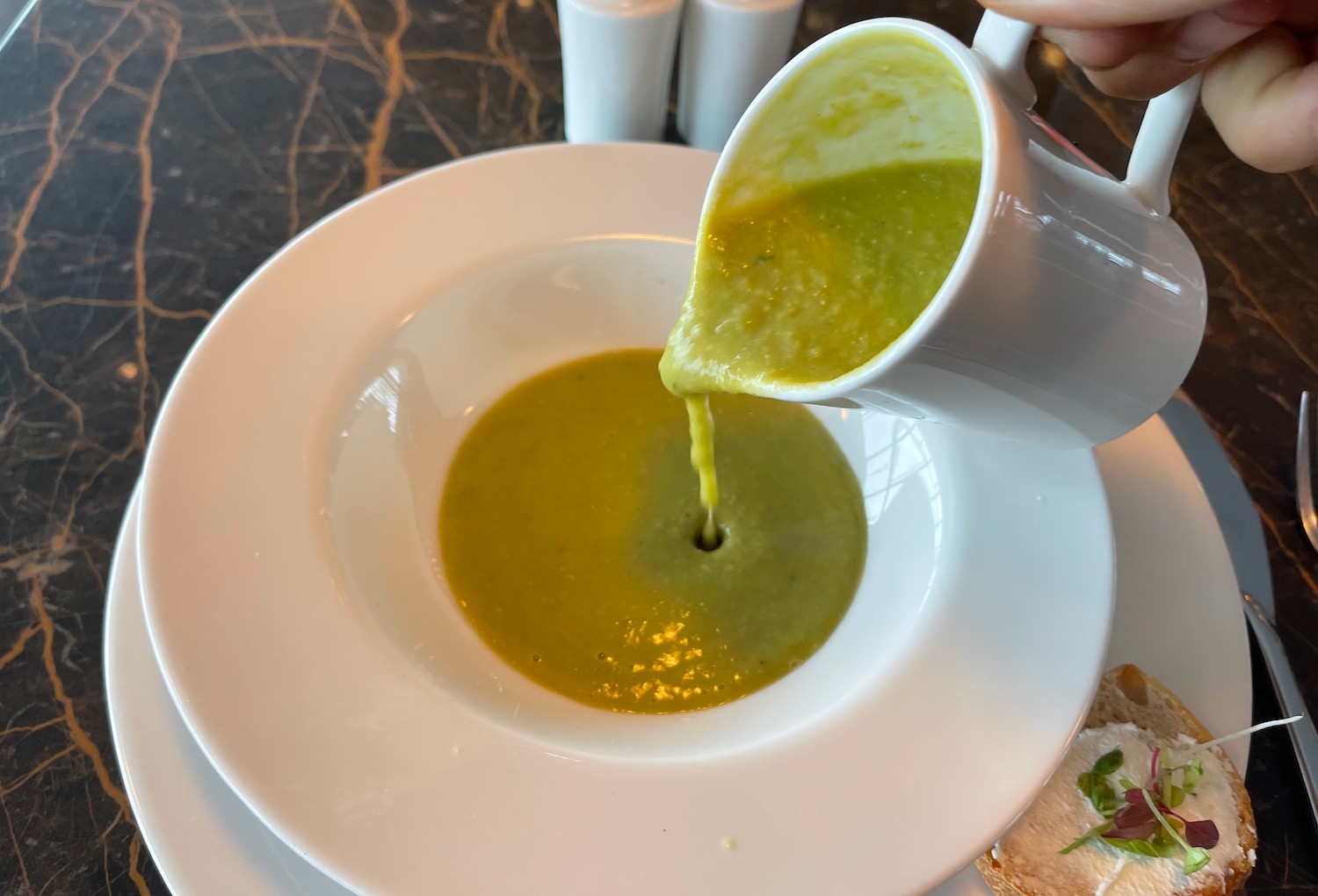 a person pouring soup into a bowl