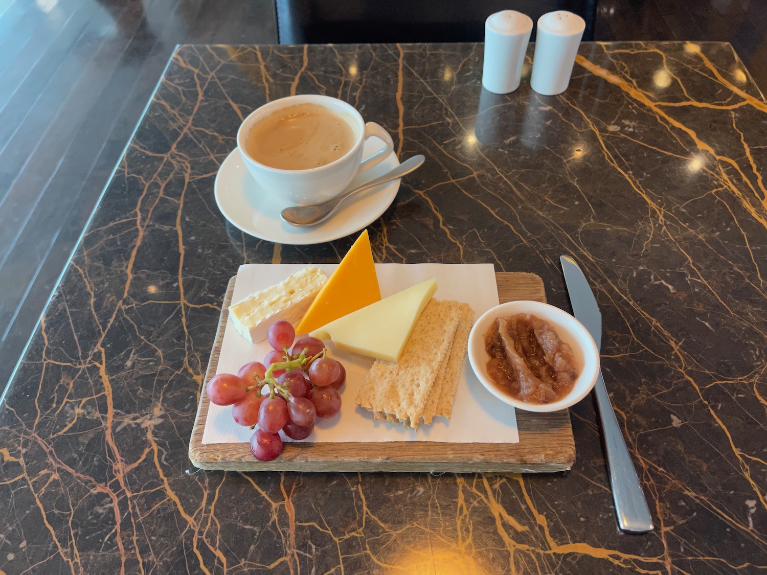 a plate of food and a cup of coffee on a marble table