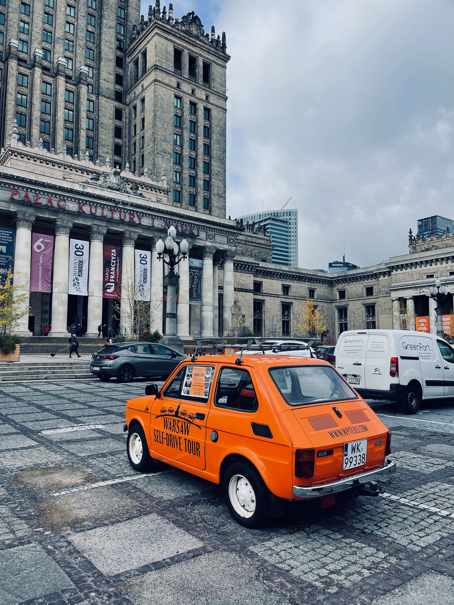 an orange car parked in a city