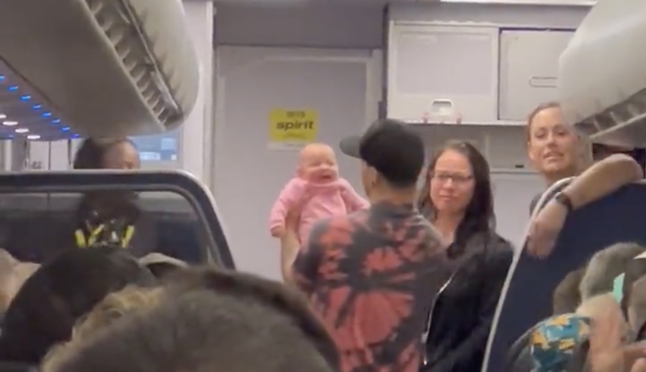 a group of people standing in a room with a baby