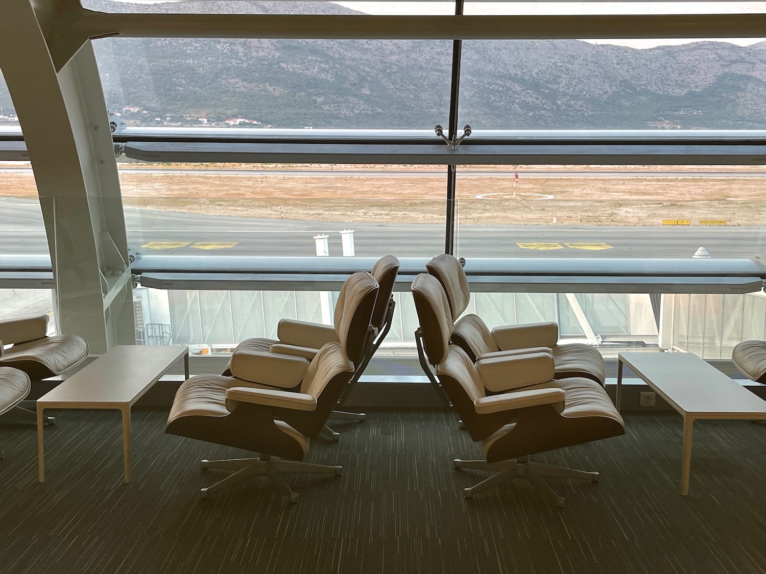 a group of chairs in a room with a table and a window