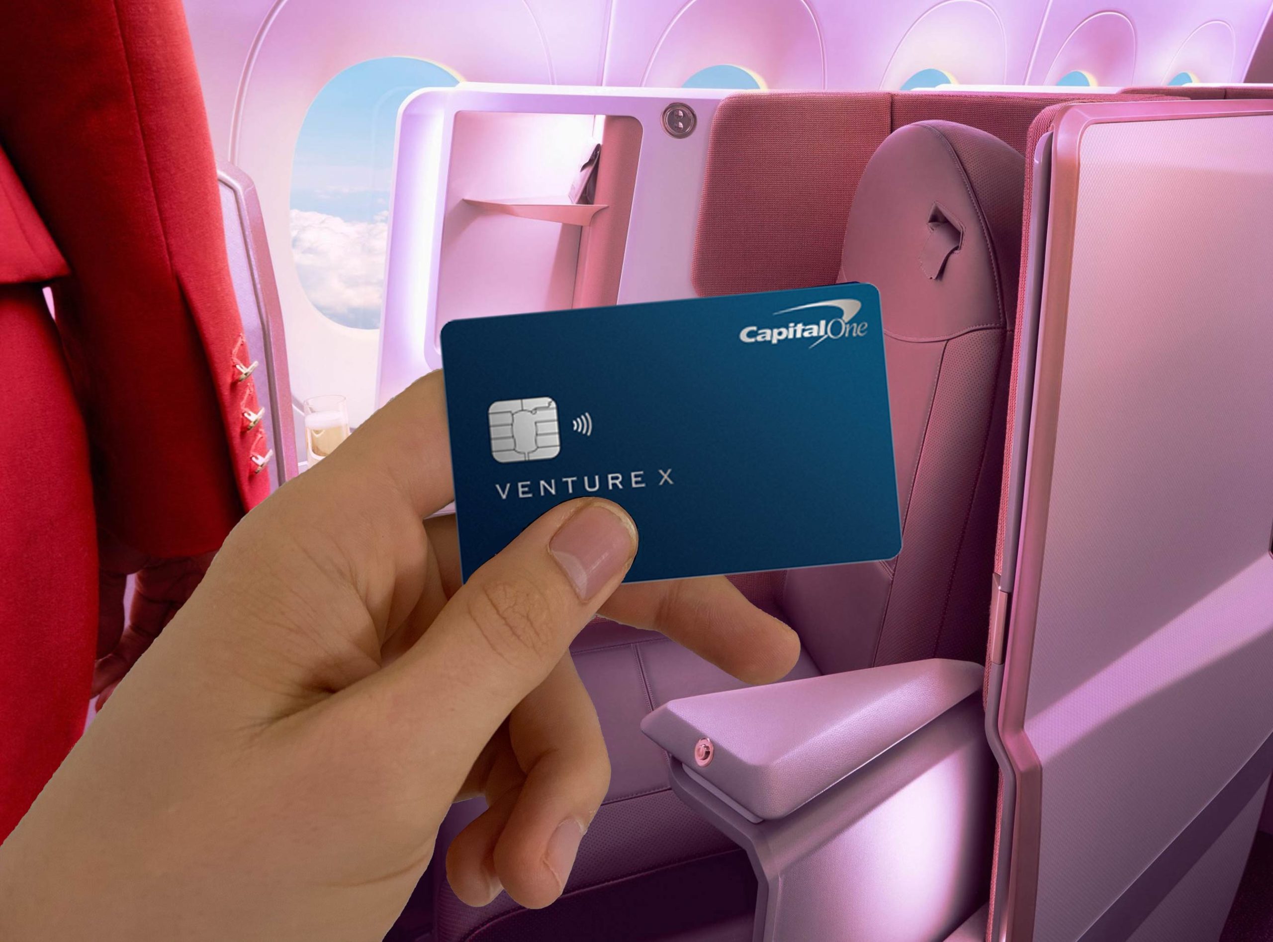 a hand holding a credit card in an airplane