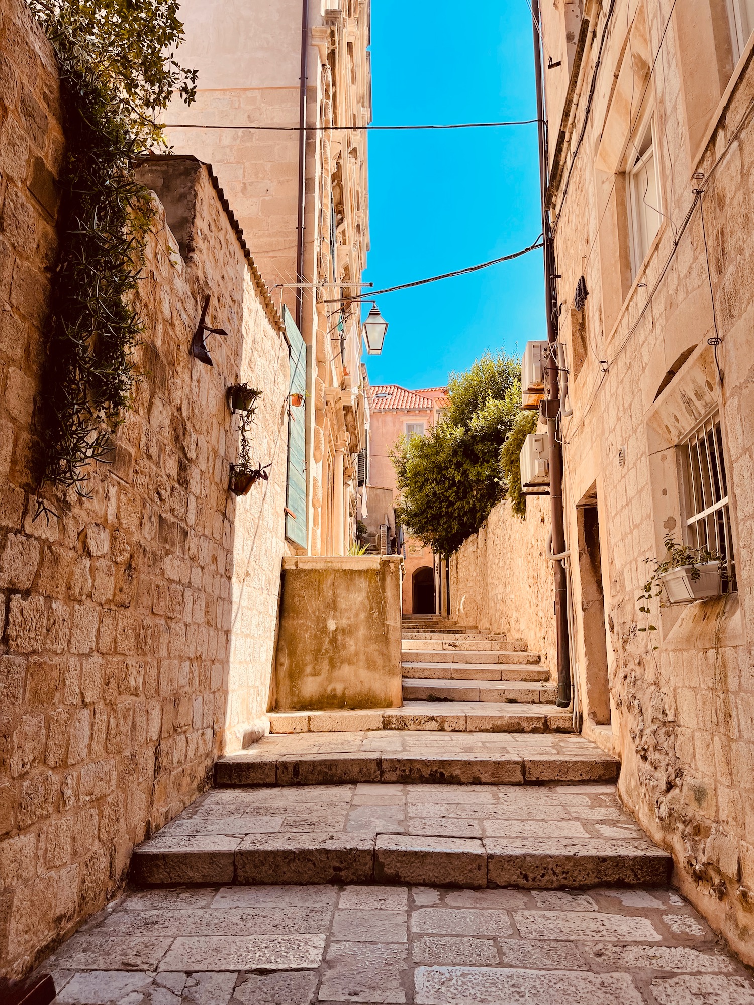 a stone alleyway with stairs and buildings