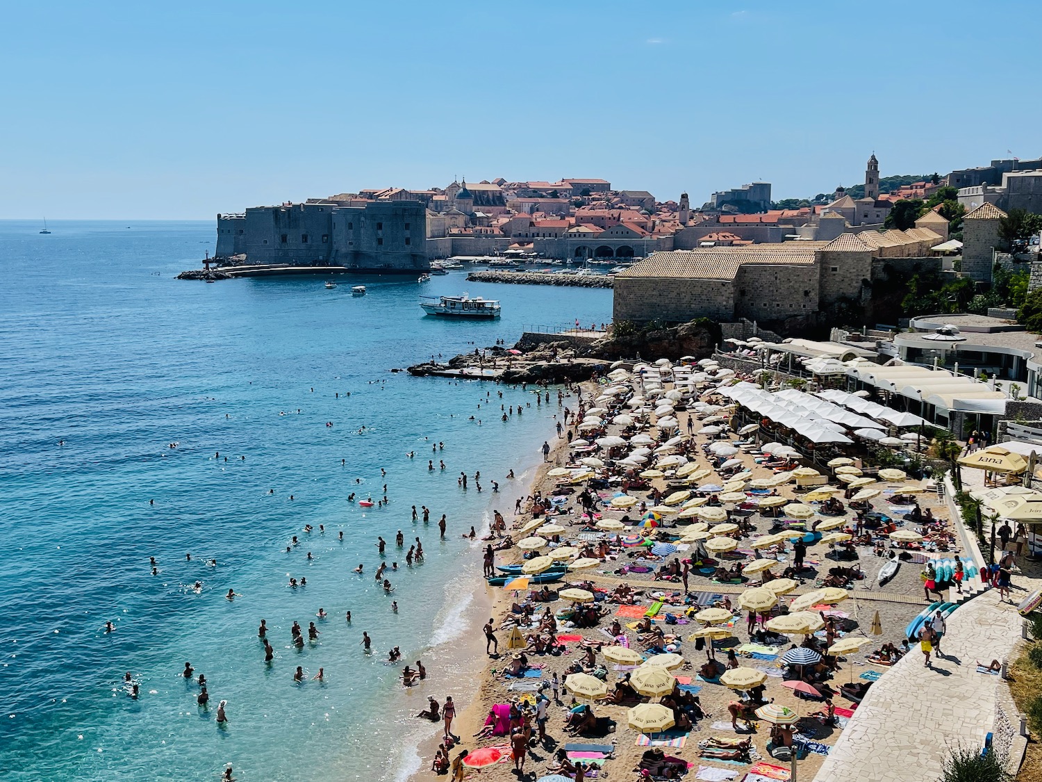 a beach with people and umbrellas