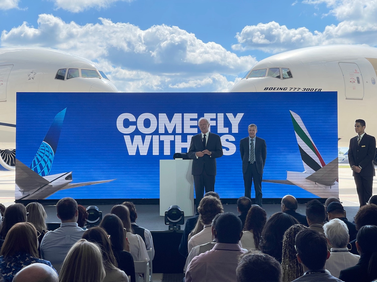 a man standing at a podium with a crowd of people in front of them