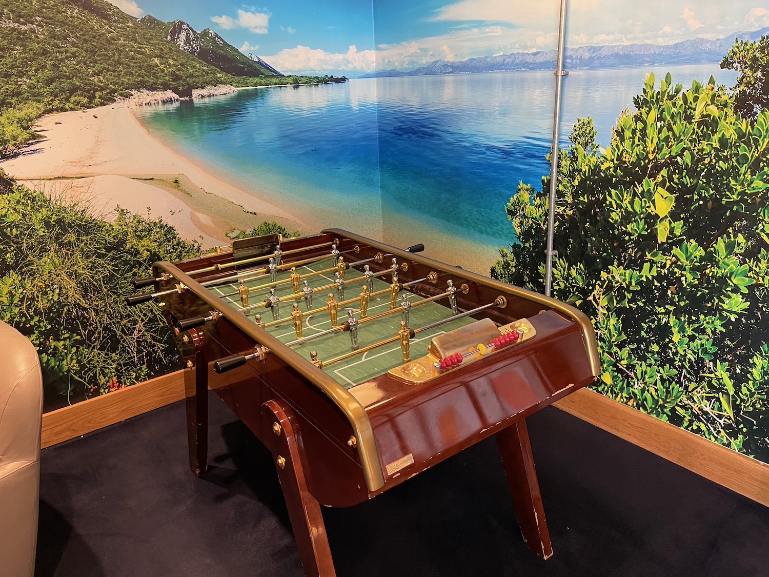 a foosball table in a room with a beach and water
