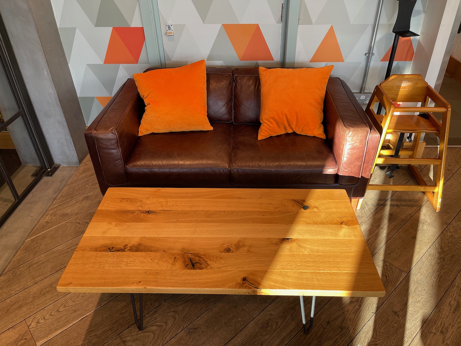 a couch with orange pillows and a wooden table