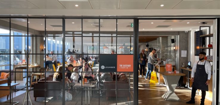 a group of people sitting at tables in a room with glass walls