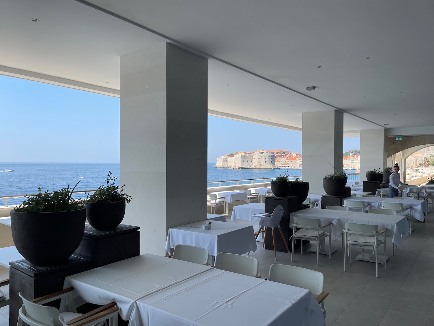 a restaurant with tables and chairs and a view of the ocean